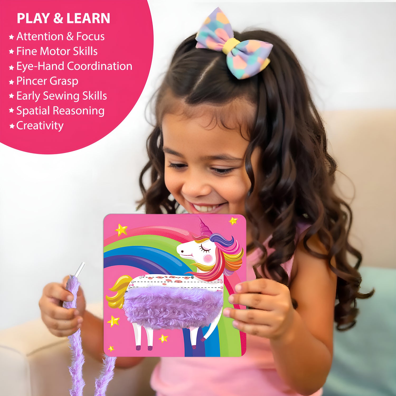 4 year old girl holding unicorn lace art craft card with fluffy yarn and smiling during DIY activity